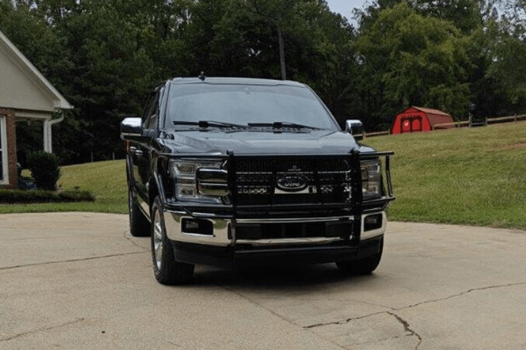 A black Ford F150 with a camera-equipped Legend grille guard by Ranch Hand emphasizing its sturdy build.