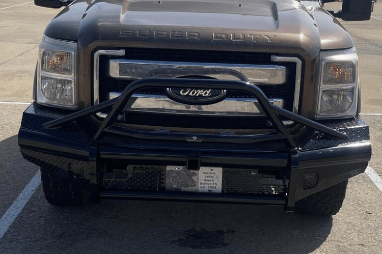 A black Ford Super Duty truck with a Ranch Hand Legend BullNose Series front bumper showcasing its robust design.