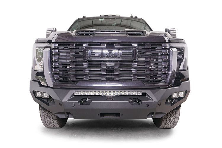 Front view of a black GMC Sierra 2500/3500 truck featuring a large grille and Fab Fours Matrix front bumper, winch ready.