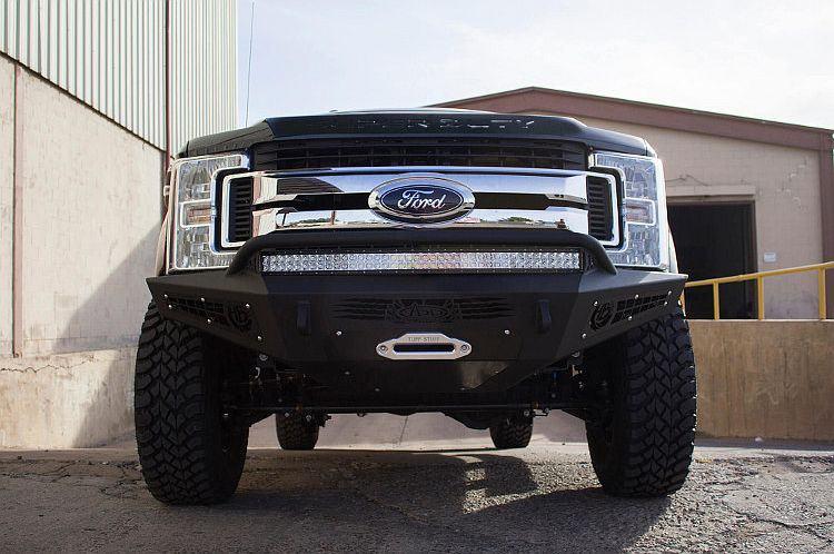 Black Ford F250/F350 Superduty pickup truck equipped with ADD Honeybadger front bumper F167382840103, suitable for winches and additional light mounts